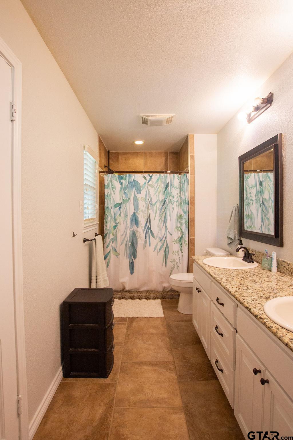 2110 Inwood Circle Tyler, TX 75701 - Photo 17 of 44 a spacious bathroom with a granite countertop sink a toilet and a shower