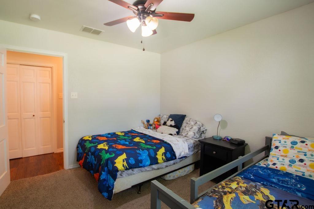 2110 Inwood Circle Tyler, TX 75701 - Photo 20 of 44 a bedroom with a bed and wooden floor