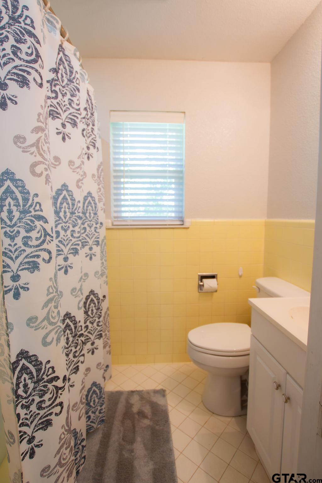 2110 Inwood Circle Tyler, TX 75701 - Photo 25 of 44 a bathroom with a toilet and a shower curtain