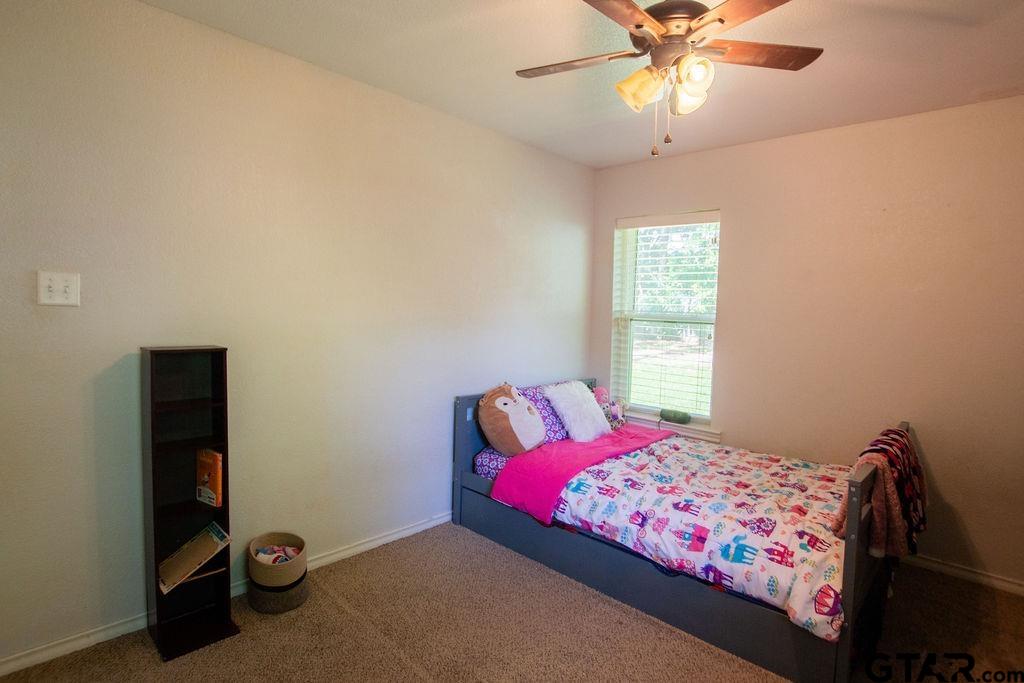 2110 Inwood Circle Tyler, TX 75701 - Photo 29 of 44 a bedroom with a bed and a chandelier