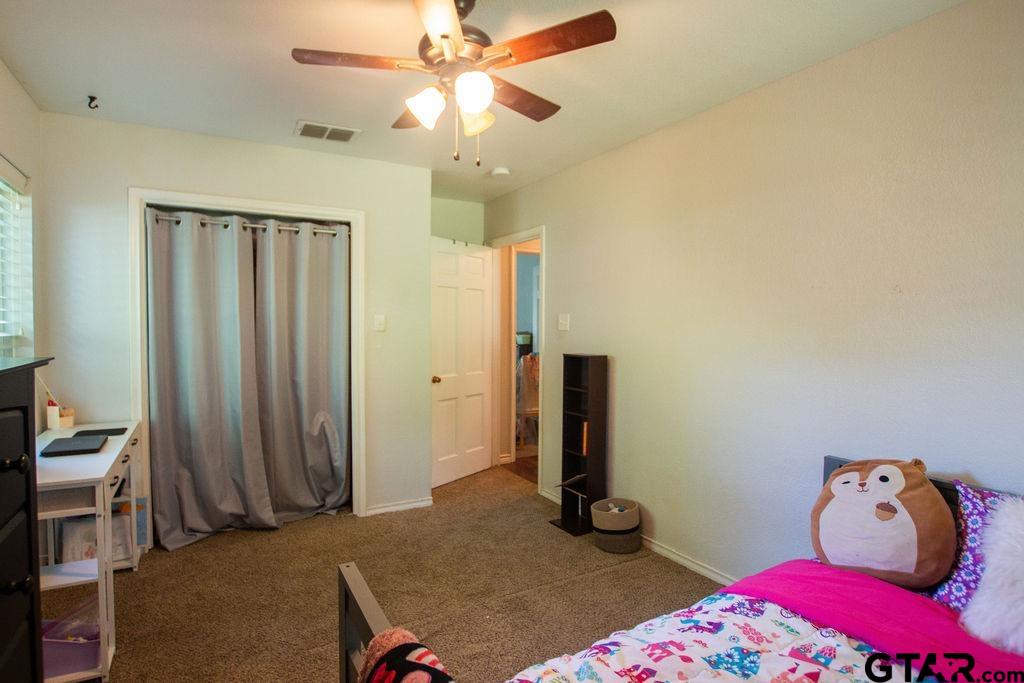 2110 Inwood Circle Tyler, TX 75701 - Photo 30 of 44 a bedroom with a bed and a chandelier fan
