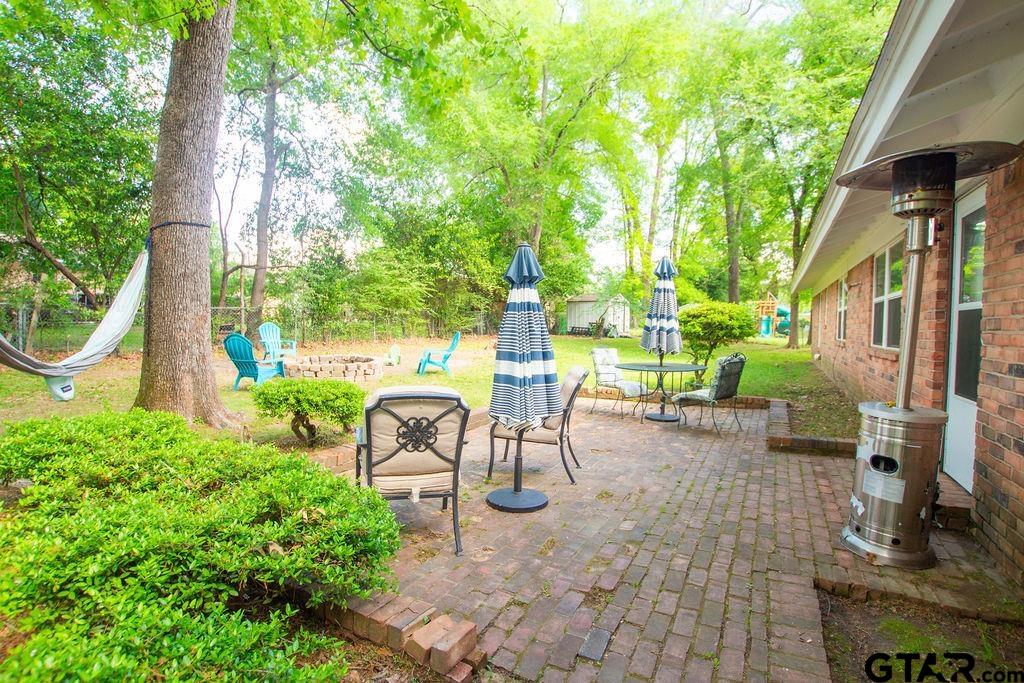 2110 Inwood Circle Tyler, TX 75701 - Photo 35 of 44 a view of a patio with table and chairs potted plants and large tree