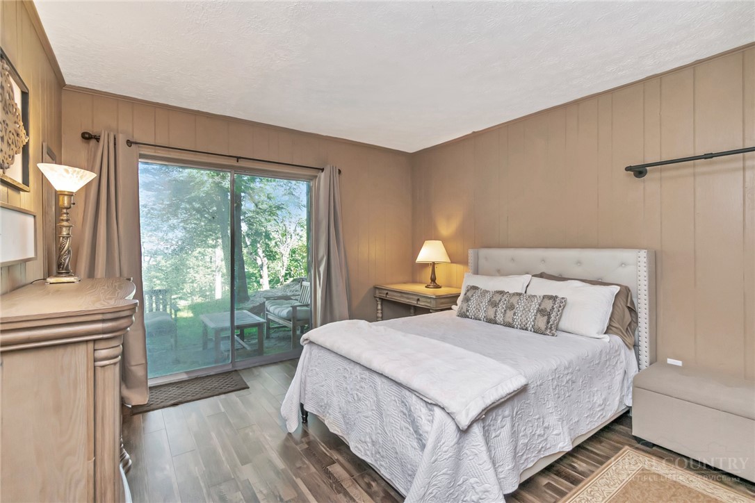 115 North Pinnacle Ridge Road, Unit 46 Beech Mountain, NC 28604 - Photo 28 of 42 a bedroom with a bed lamp and a large window with outer view