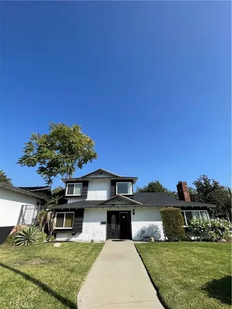 a front view of a house with a garden and yard