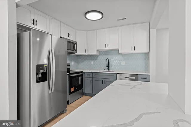 a kitchen with stainless steel appliances a refrigerator and a sink