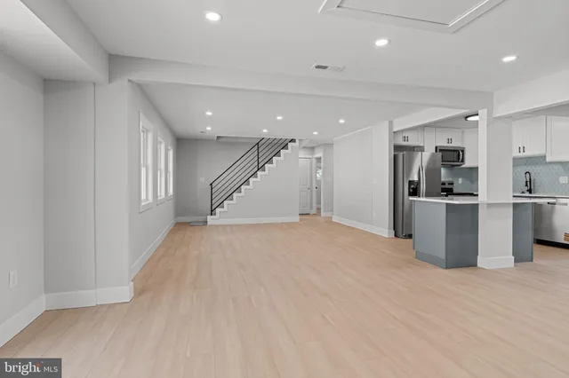 a kitchen with stainless steel appliances kitchen island wooden cabinets and entryway