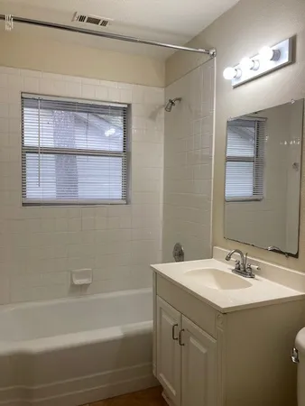 a bathroom with a sink vanity tub and a mirror