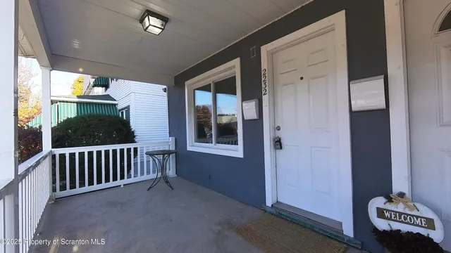 a view of a porch with furniture and floor to ceiling window