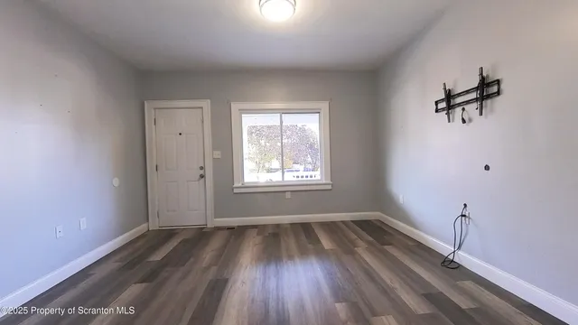 a view of a room with a wooden floor and a window