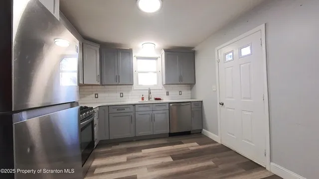 a kitchen with a sink stainless steel appliances and cabinets