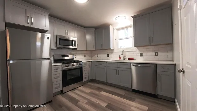 a kitchen with stainless steel appliances a refrigerator sink and microwave