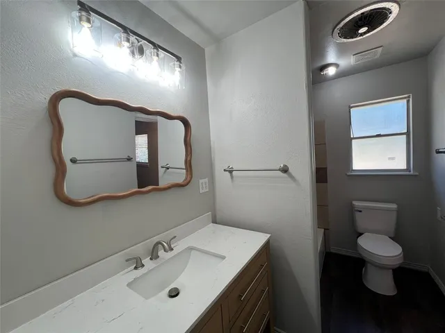 a bathroom with a toilet sink and mirror