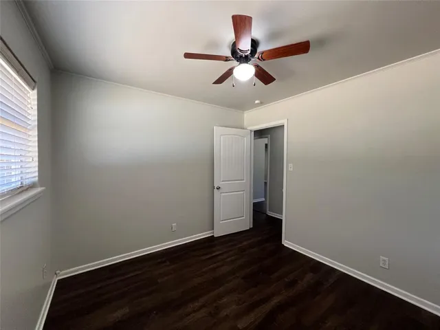 a view of a room with wooden floor and a ceiling fan