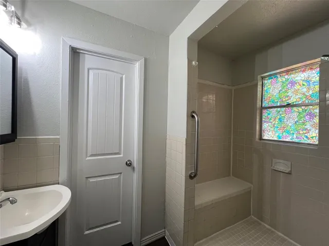 a bathroom with a tub a sink and a window