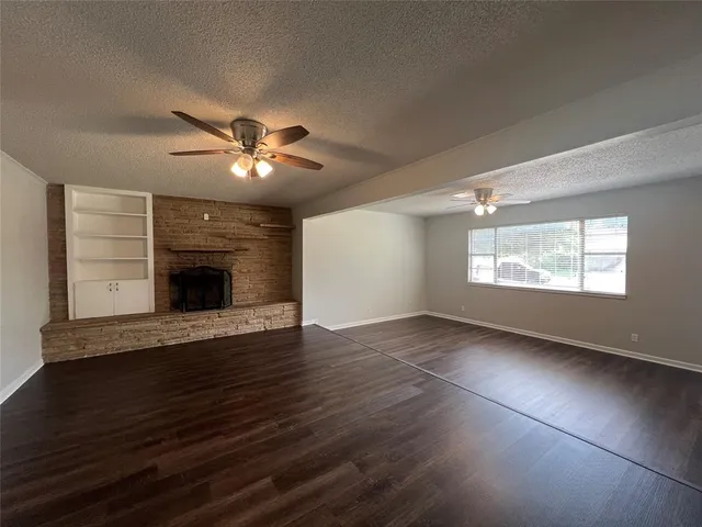 a view of an empty room with a fireplace and a window