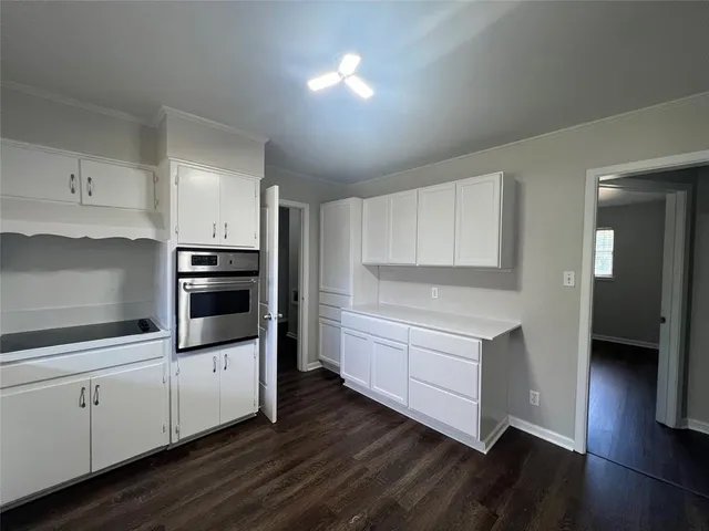 a kitchen with cabinets stove and wooden floor