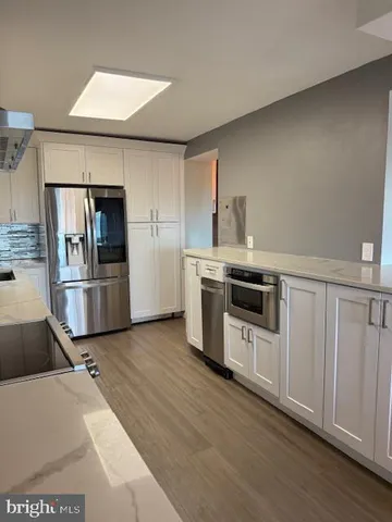 a kitchen with stainless steel appliances granite countertop a refrigerator and a stove