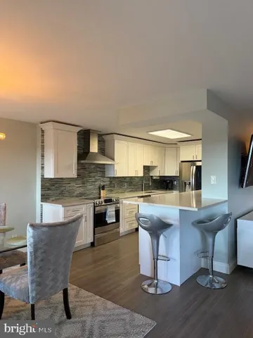 a kitchen with kitchen island a sink stove and view living room