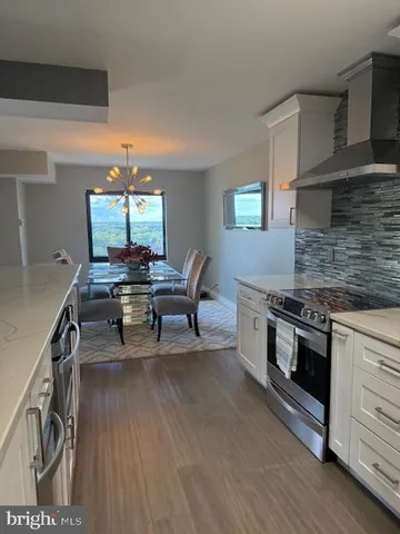a kitchen with stainless steel appliances granite countertop a stove and a wooden floors