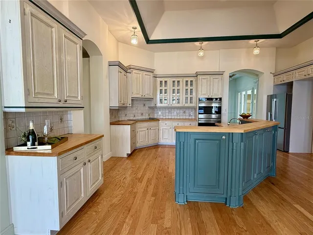 a kitchen with stainless steel appliances granite countertop wooden cabinets a sink and dishwasher with wooden floor