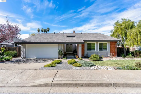 a front view of a house with a yard and potted plants