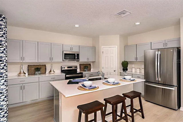 a kitchen with stainless steel appliances a refrigerator stove microwave and cabinets