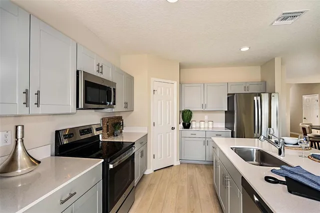 a kitchen with a sink a stove top oven and refrigerator