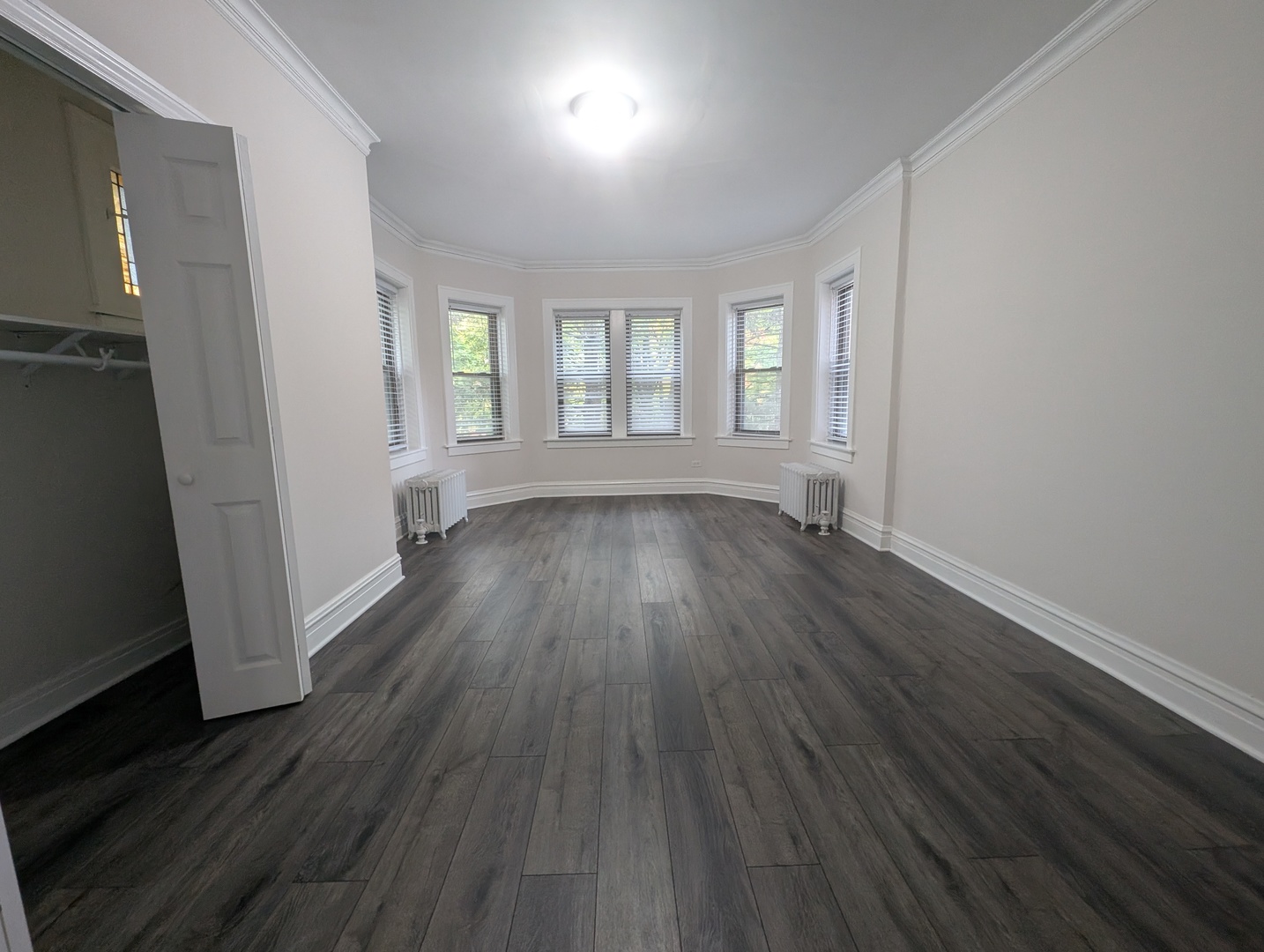 5820 West Berteau Avenue, Unit 2 Chicago, IL 60634 - Photo 4 of 12 an empty room with wooden floor and windows