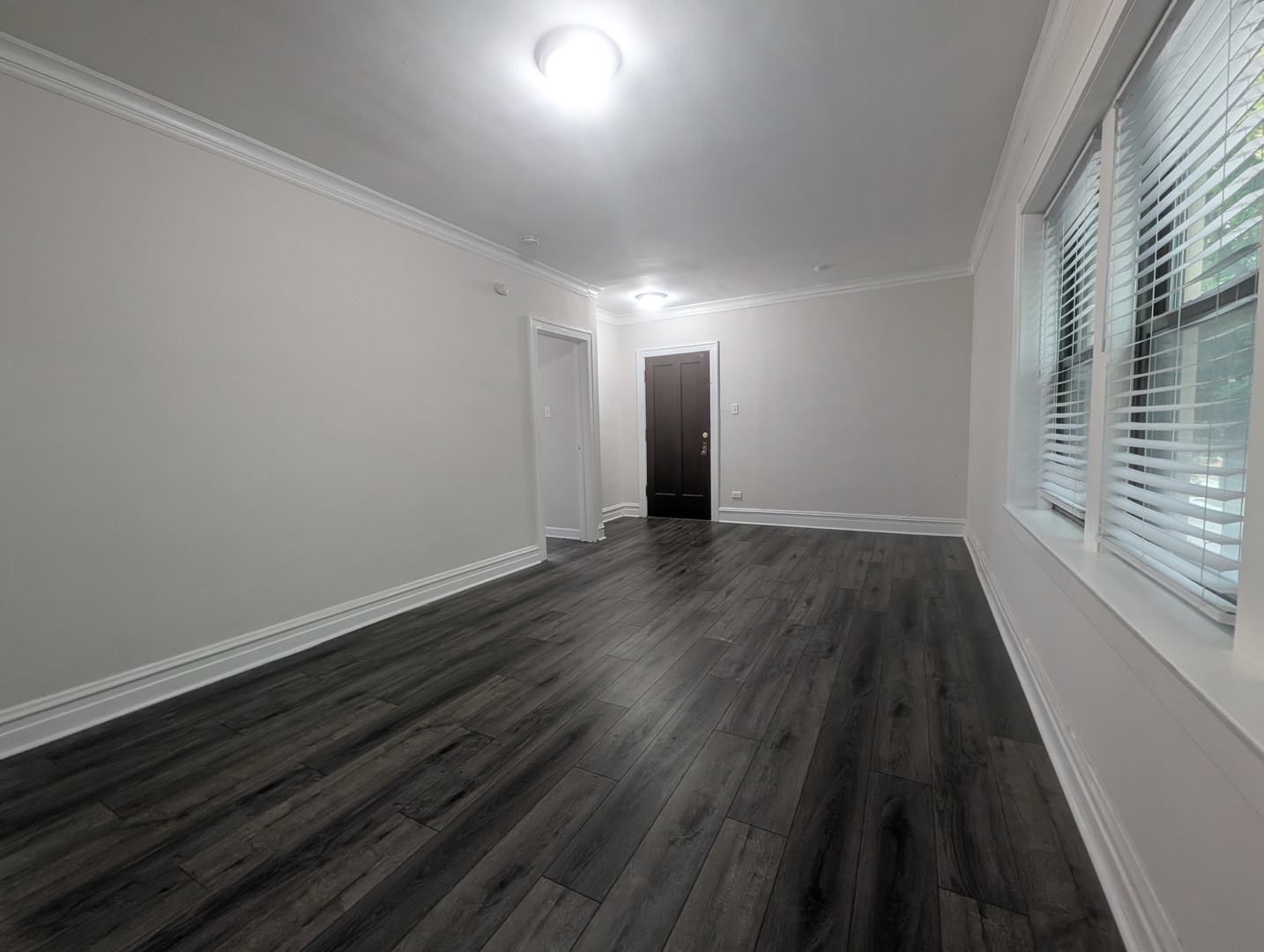 5820 West Berteau Avenue, Unit 2 Chicago, IL 60634 - Photo 5 of 12 a view of an empty room with wooden floor and a window