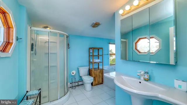 a bathroom with a granite countertop shower a toilet and a sink