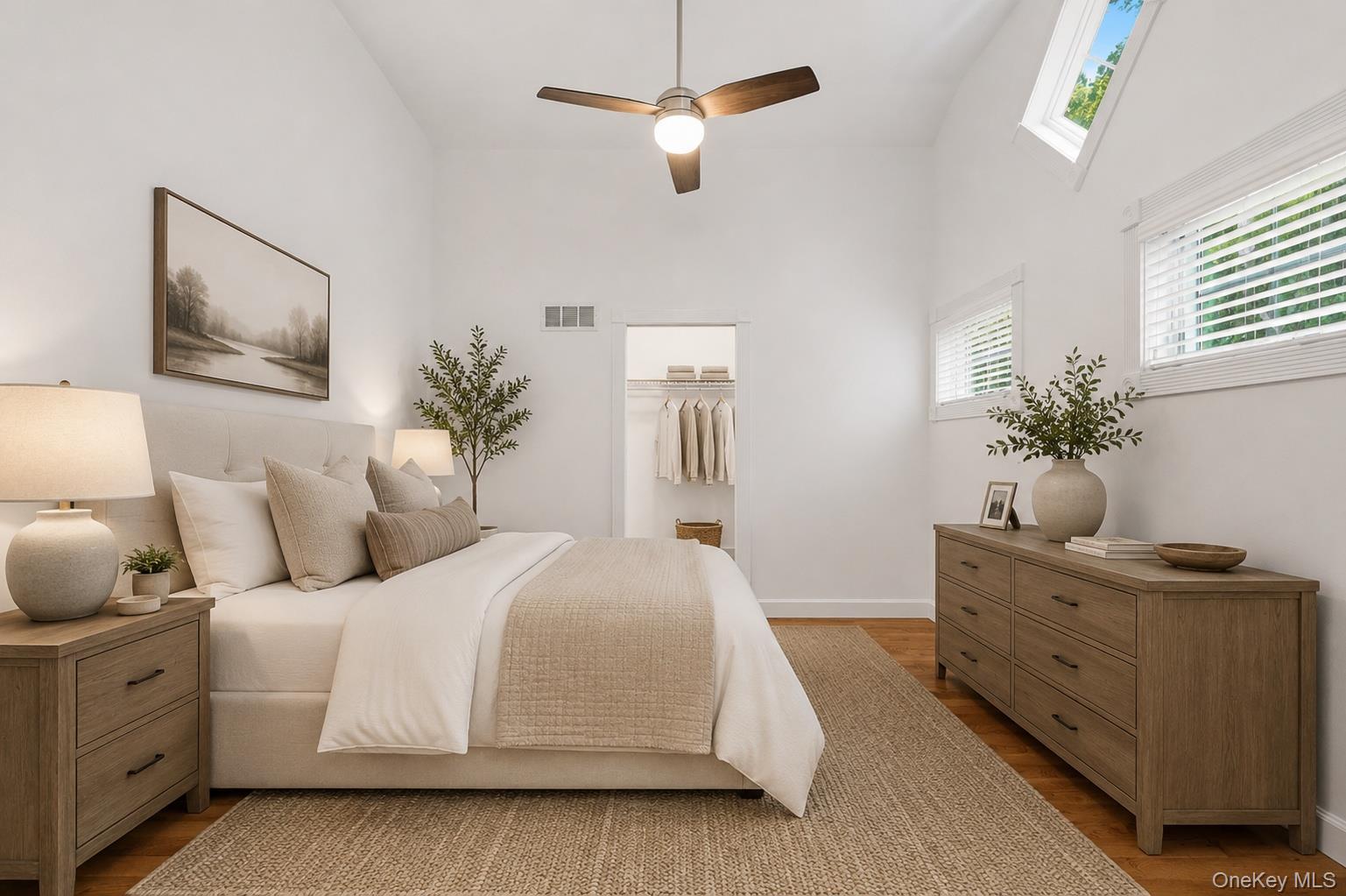 12 Leeside Road Carmel, NY 10512 - Photo 21 of 44 Vaulted ceiling bedroom 2 on the first level featuring wood-finish flooring, a ceiling fan with integrated lighting, and multiple windows including two skylights