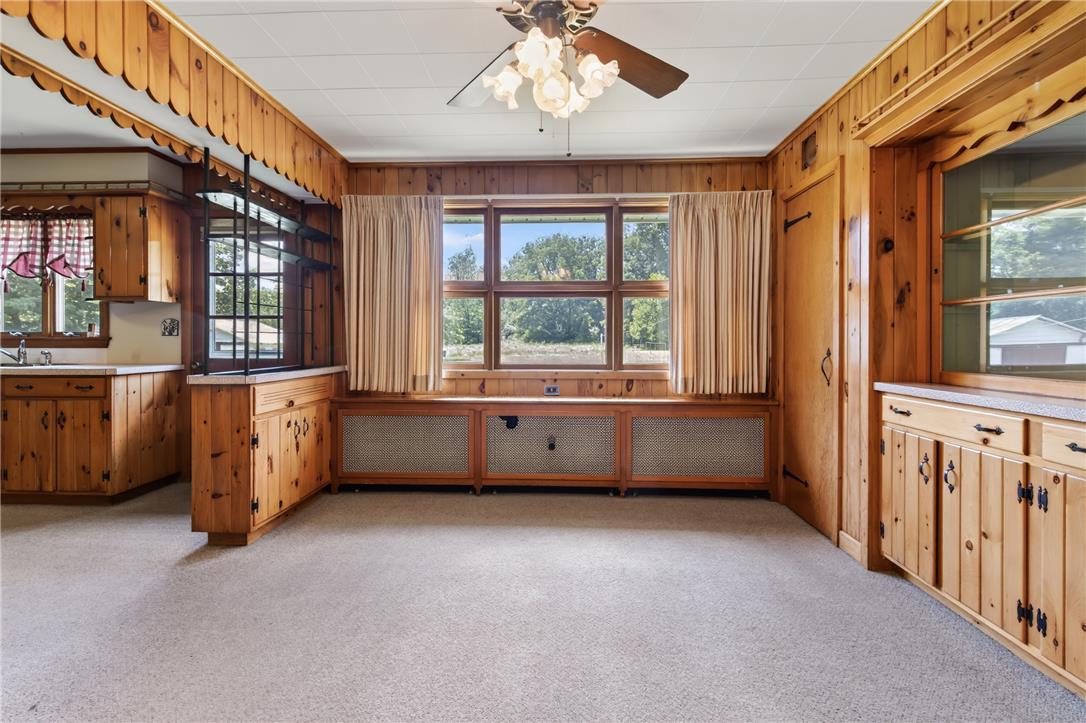 51 Reynolds Road Tamaqua, PA 18252 - Photo 12 of 71 A well-lit interior space features natural wood paneling, a large window offering outdoor views, and a ceiling fan.
