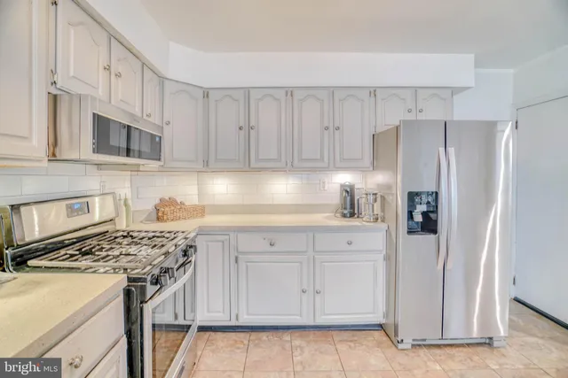 a kitchen with stainless steel appliances granite countertop a refrigerator sink and stove