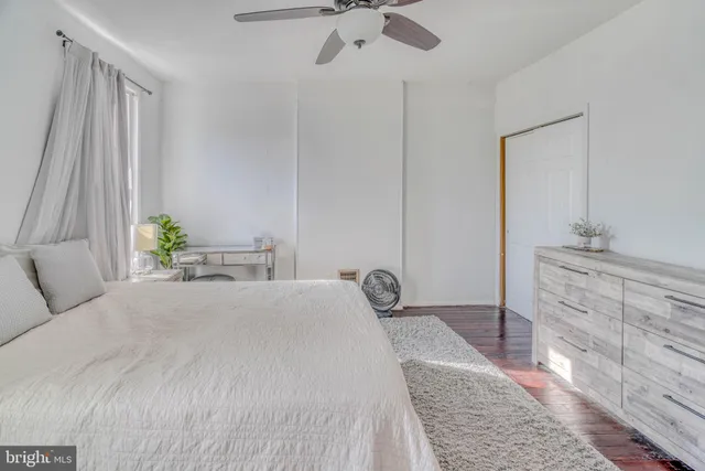 a bedroom with a bed and a chandelier fan