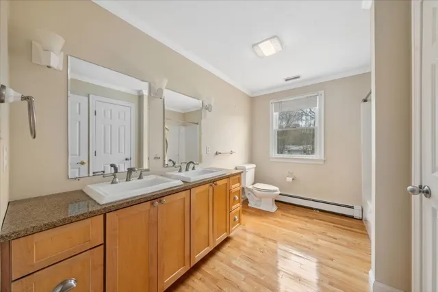 a bathroom with a granite countertop double vanity sink a mirror and a