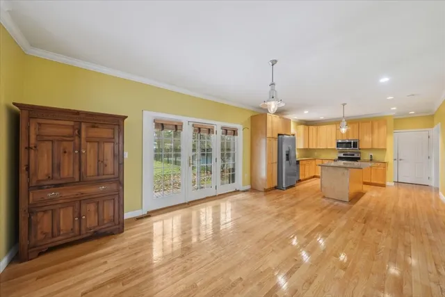 a view of a kitchen with refrigerator and wooden floor