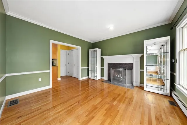 a view of an empty room with a fireplace and a window