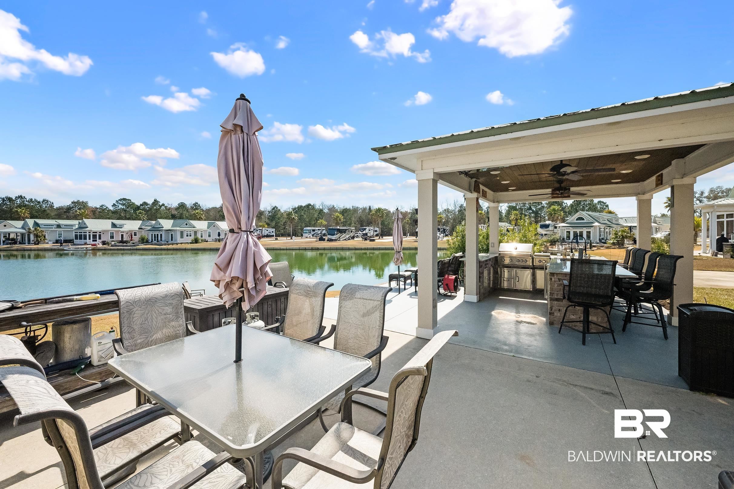 11996 Raptor Court Elberta, AL 36530 - Photo 2 of 45 View of patio featuring a ceiling fan, a residential view, an outdoor kitchen / dining area, and a water view