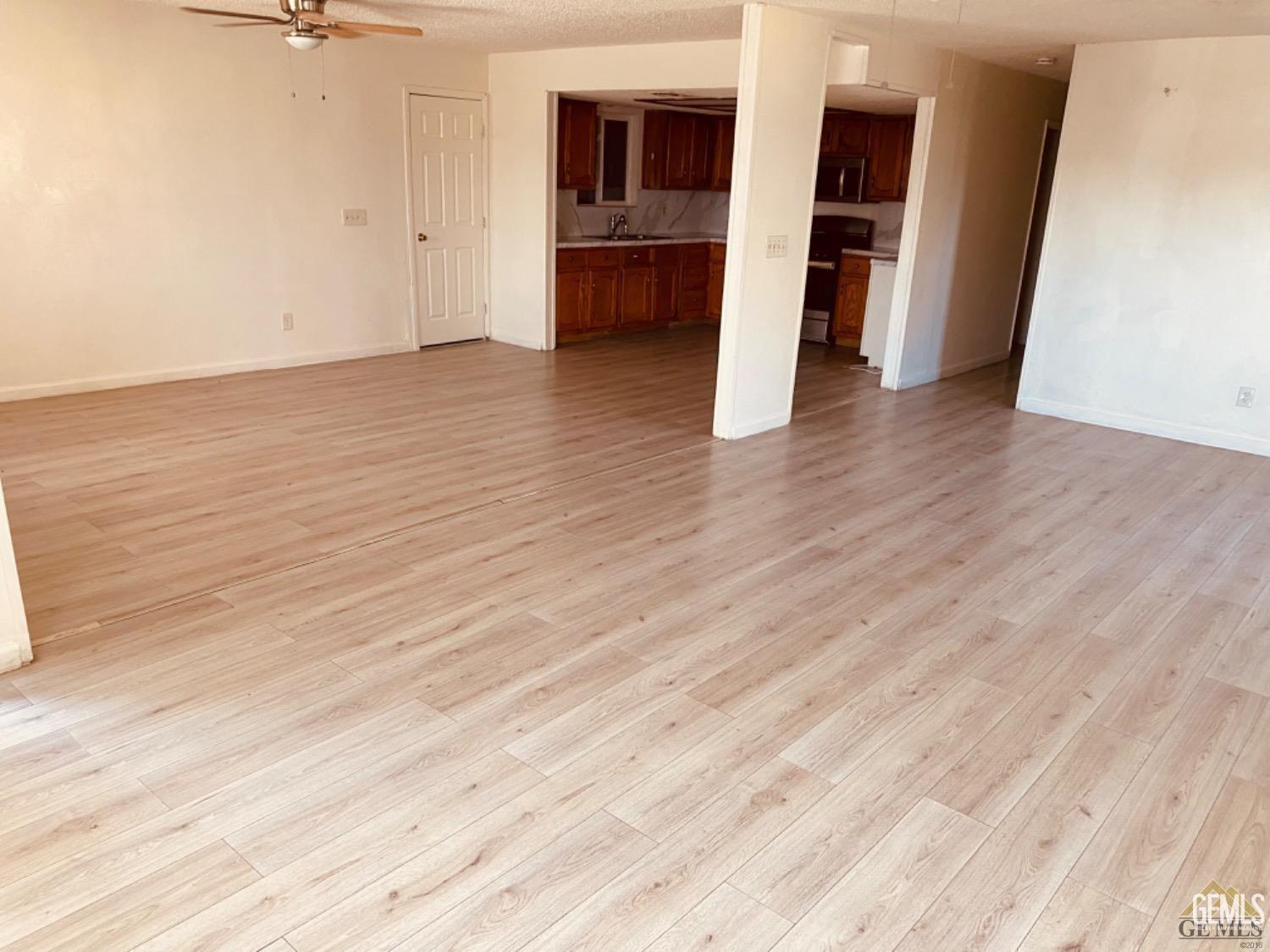 Undisclosed Address Delano, CA 93215 - Photo 2 of 7 an empty room with wooden floor and a ceiling fan