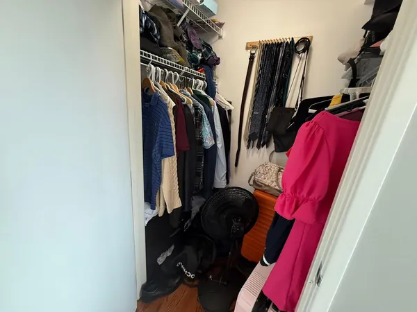 a view of walk in closet with clothes and shoes