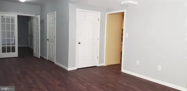 an empty room with wooden floor and closet