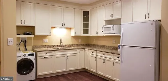 a kitchen with white cabinets and white appliances