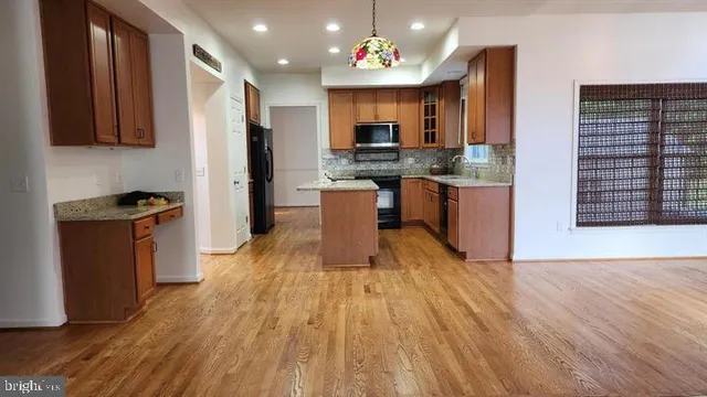 a kitchen with a refrigerator a stove top oven a sink dishwasher and wooden floor