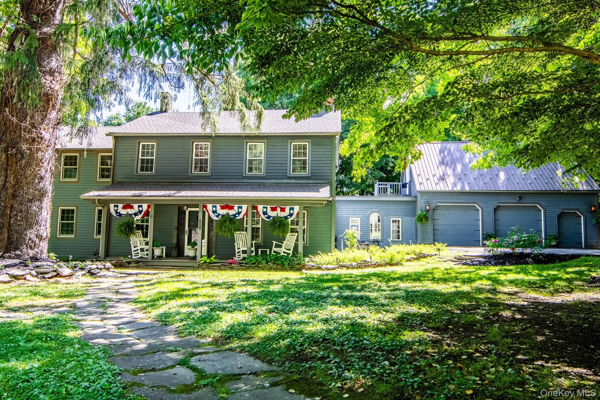Traditional Colonial Style home has a rocking chair porch and attached 3 car garage