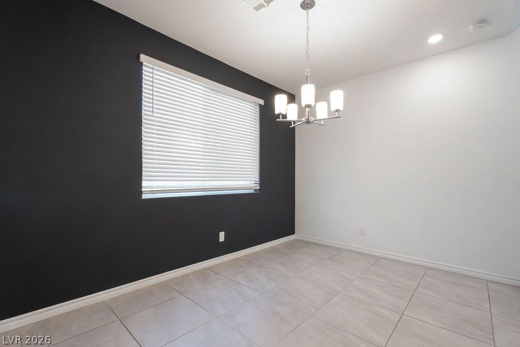 7126 Calvert Cliffs Street North Las Vegas, NV 89084 - Photo 12 of 44 A well-lit room featuring contemporary light fixtures and a window with blinds.
