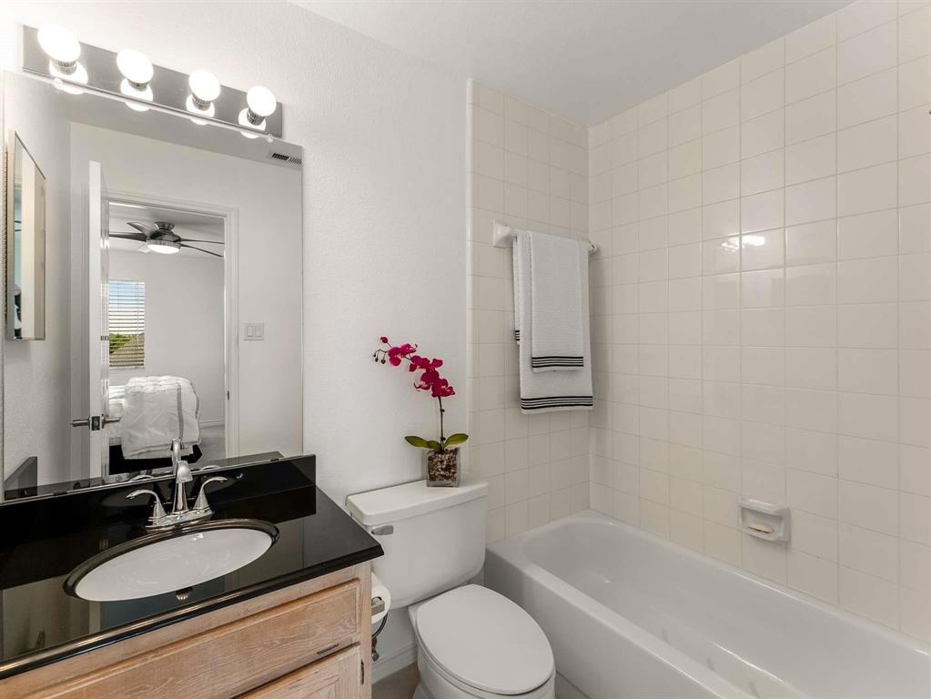7436 Stoney Point Drive Plano, TX 75025 - Photo 13 of 40 a bathroom with a granite countertop sink mirror toilet and bathtub