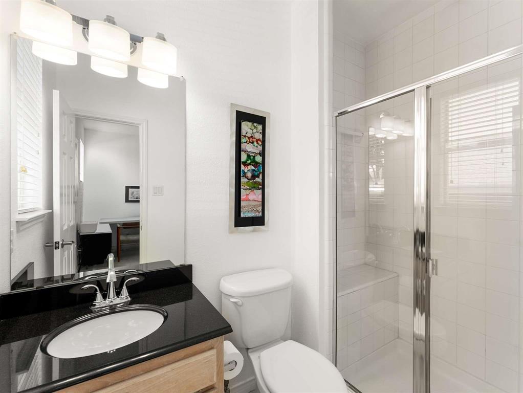 7436 Stoney Point Drive Plano, TX 75025 - Photo 22 of 40 a bathroom with a sink toilet a mirror and shower