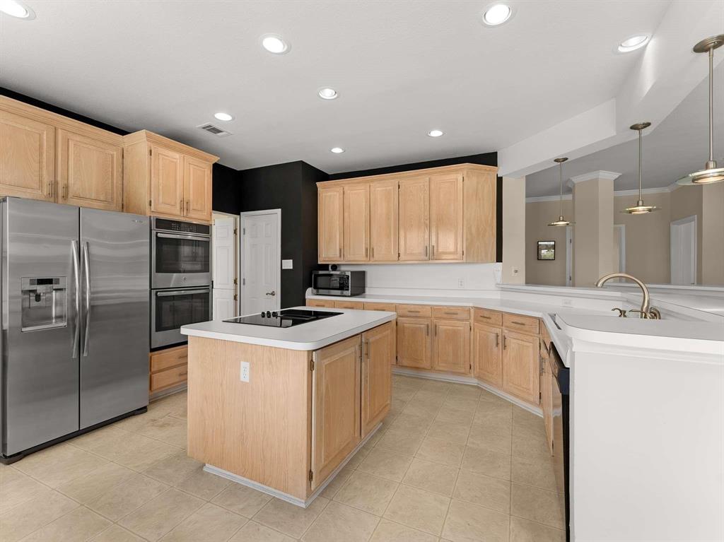7436 Stoney Point Drive Plano, TX 75025 - Photo 32 of 40 a kitchen with stainless steel appliances granite countertop a sink stove and refrigerator