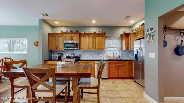 a kitchen with stainless steel appliances granite countertop a stove a sink and a refrigerator