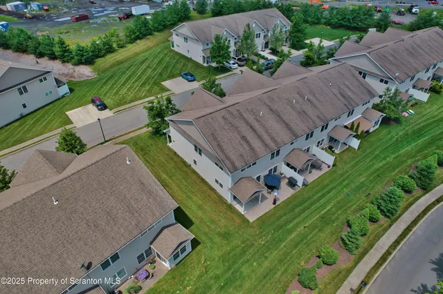 an aerial view of a house with a garden and houses